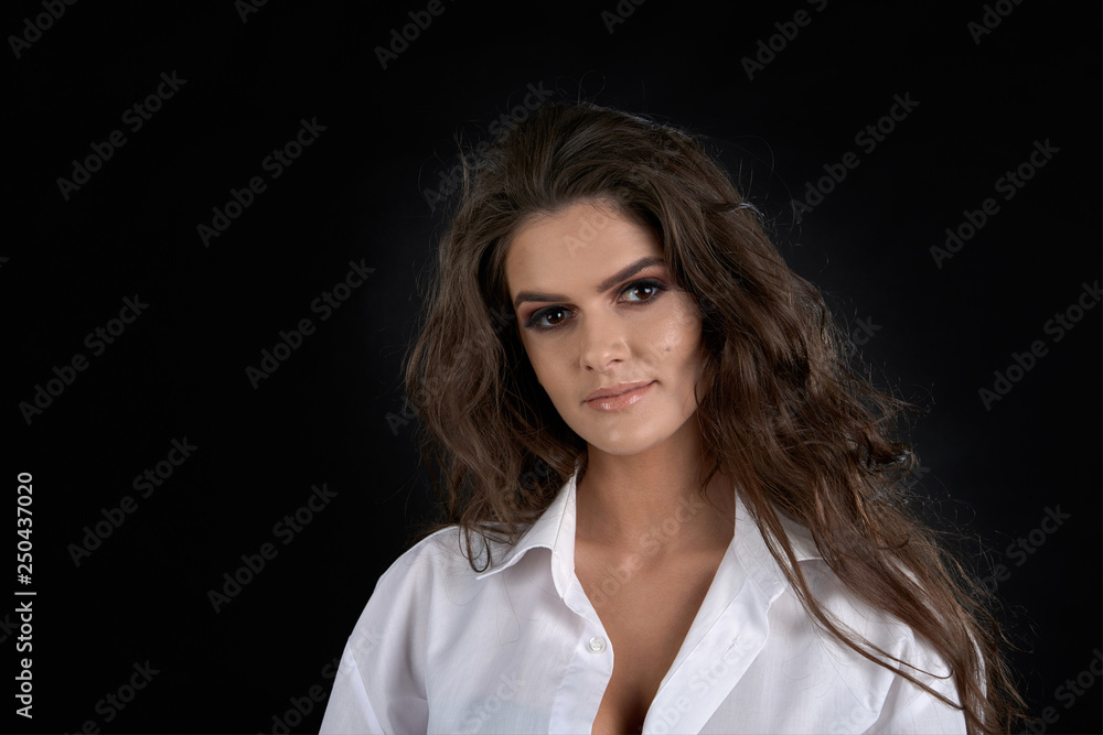 Portrait of a girl in a studio on a black background.Crazy girl with long hair and white dress. Portrait of a girl in a studio on a black background.Crazy girl with long hair and white dress.