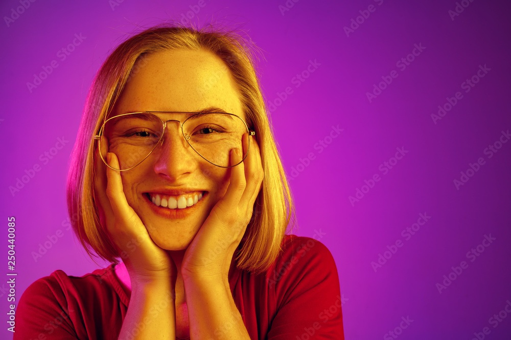 Happy business woman standing and smiling isolated on neon studio background. Beautiful female half-length portrait. Young emotional woman. The human emotions, facial expression concept Happy business woman standing and smiling isolated on neon studio background. Beautiful female half-length portrait. Young emotional woman. The human emotions, facial expression concept