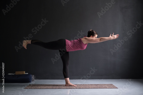 woman practicing yoga, doing Warrior III exercise, Virabhadrasana 3 pose