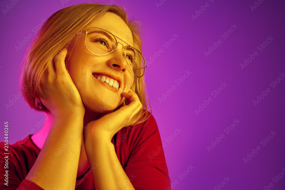 Happy business woman standing and smiling isolated on neon studio background. Beautiful female half-length portrait. Young emotional woman. The human emotions, facial expression concept Happy business woman standing and smiling isolated on neon studio background. Beautiful female half-length portrait. Young emotional woman. The human emotions, facial expression concept