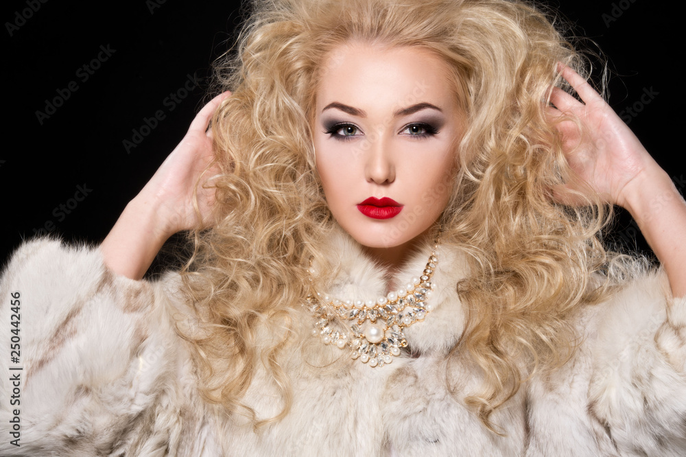 Beautiful blonde woman with curly hairstyle and bright makeup, perfect skin, cosmetology. Sexy vogue woman in fur and jewelry. Beautiful blonde woman with curly hairstyle and bright makeup, perfect skin, cosmetology. Sexy vogue woman in fur and jewelry.