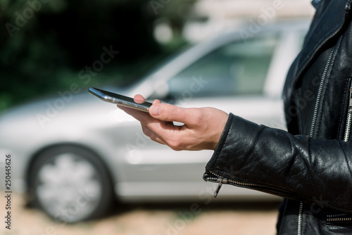 Close up on person hold keeping cellphone in the pocket, outdoors automobile transportation background. modern lifestyle communication technology, emergency stop navigation mobility assistance.