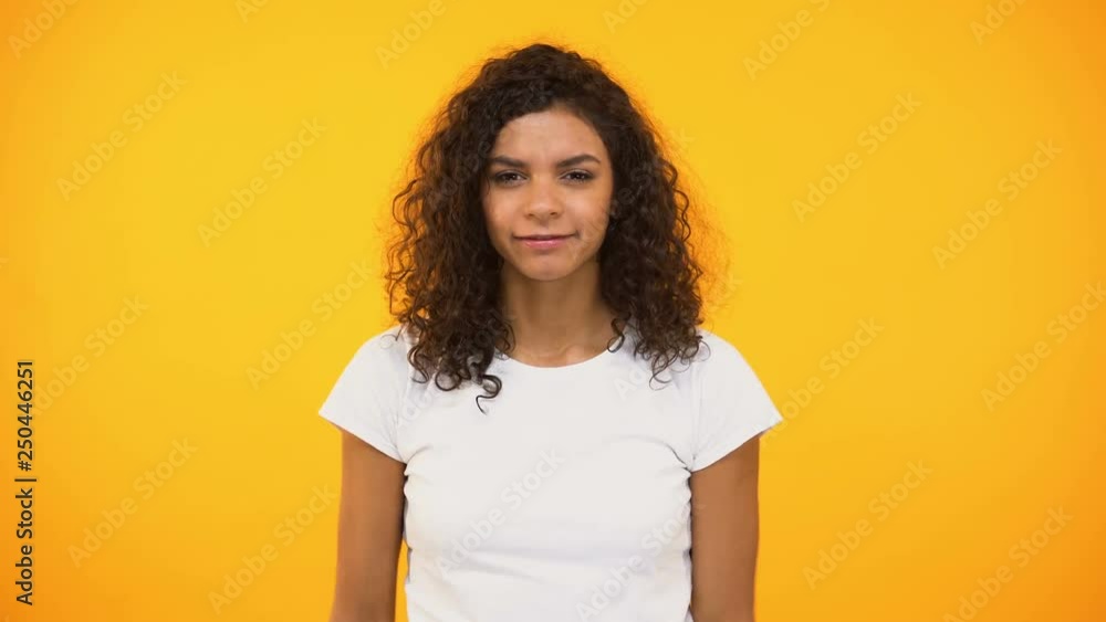 African american girl screaming to camera against yellow background, protest African american girl screaming to camera against yellow background, protest