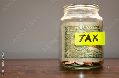 jar with coins and dollar inside with mark tax on it