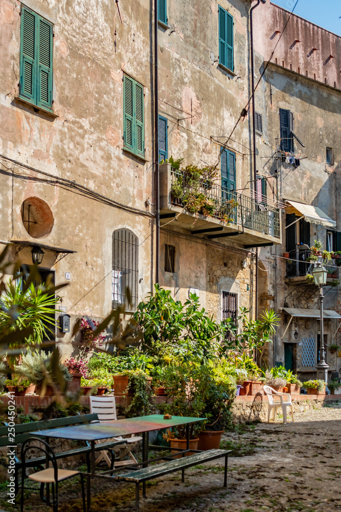 Plaza mit Tischen und Bänken in der mittelalterlichen Altstadt von Cervo in Ligurien Italien