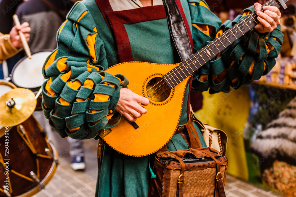 Fototapeta Średniowieczny trubadur grający na antycznej gitarze.