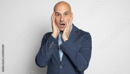 Shocked bald man looking at camera. Isolated