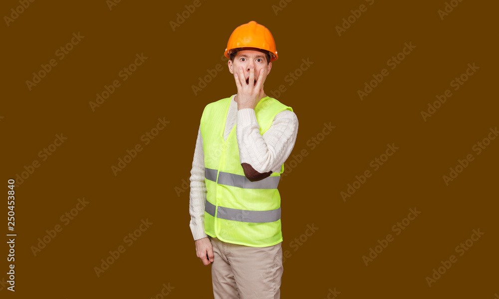 the man in a construction helmet, a vest closed a mouth a hand the man in a construction helmet, a vest closed a mouth a hand