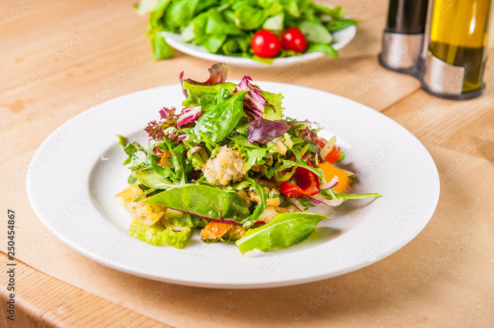 Fresh green salad with spinach,arugula,romaine, lettuce, beet leaves, bell pepper and croutons on the wooden served table. Healthy vegetarian food. Selective focus, copy space. Fresh green salad with spinach,arugula,romaine, lettuce, beet leaves, bell pepper and croutons on the wooden served table. Healthy vegetarian food. Selective focus, copy space.