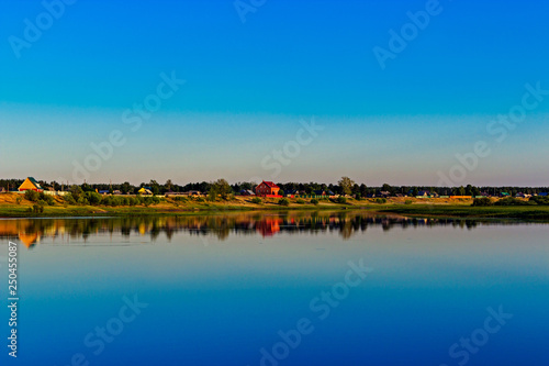russian village on the lake in the summer evening