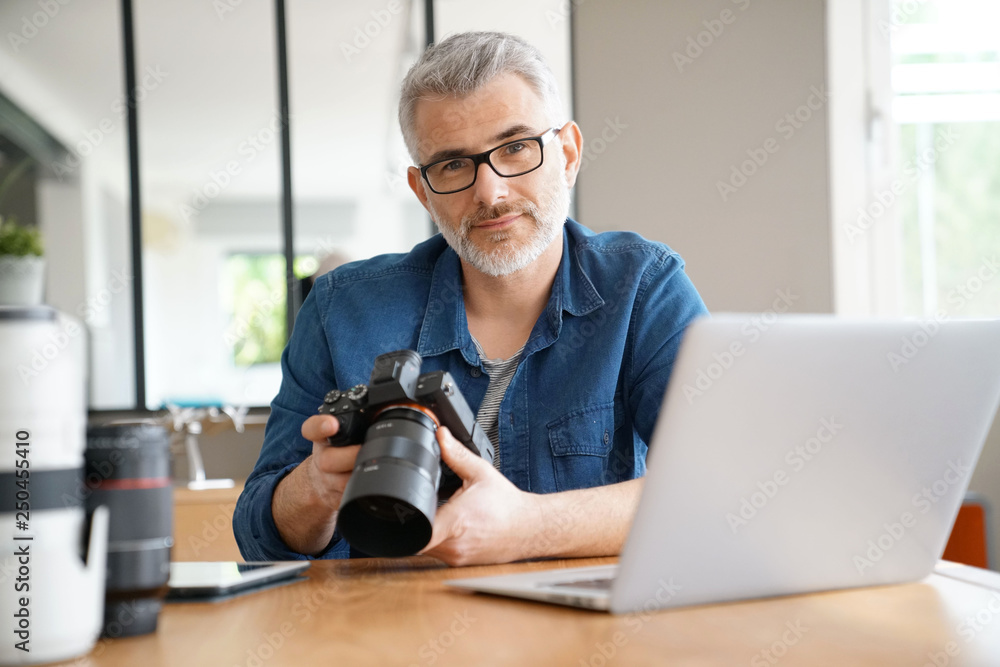 Photographer in office checking shots Photographer in office checking shots