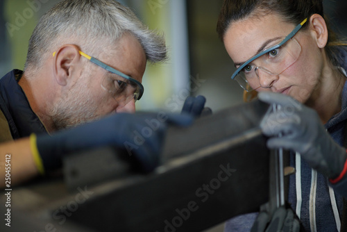 Tableau sur toile Metalworker with apprentice in workshop