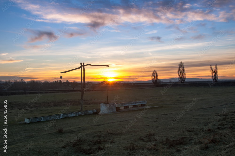 Traditional water well (well sweep or shadoof) in Serbia with a beautifull sunset