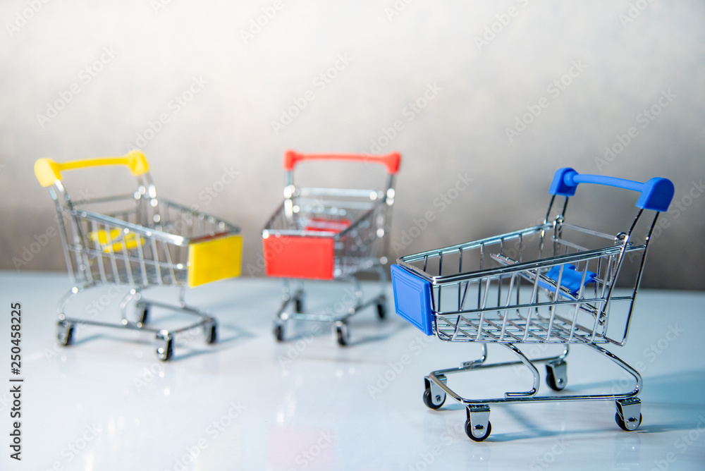 Mini shopping cart or shopping trolley on the table. Supermarket grocery push cart. Buying concept. Mini shopping cart or shopping trolley on the table. Supermarket grocery push cart. Buying concept.