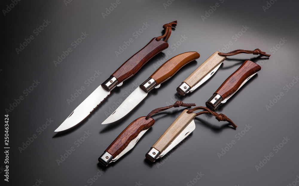 folding pen knives with wooden handles on a gradient gray-black back folding pen knives with wooden handles on a gradient gray-black back