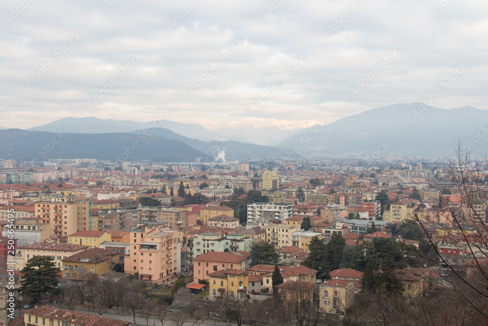 Brescia cityscape with snow covered mountains on background, Lombardy, Italy.