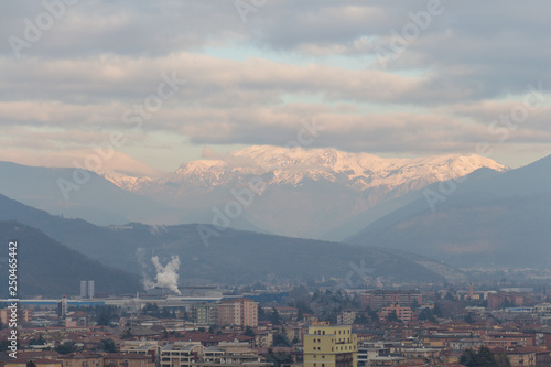 Brescia cityscape with snow covered mountains on background, Lombardy, Italy.