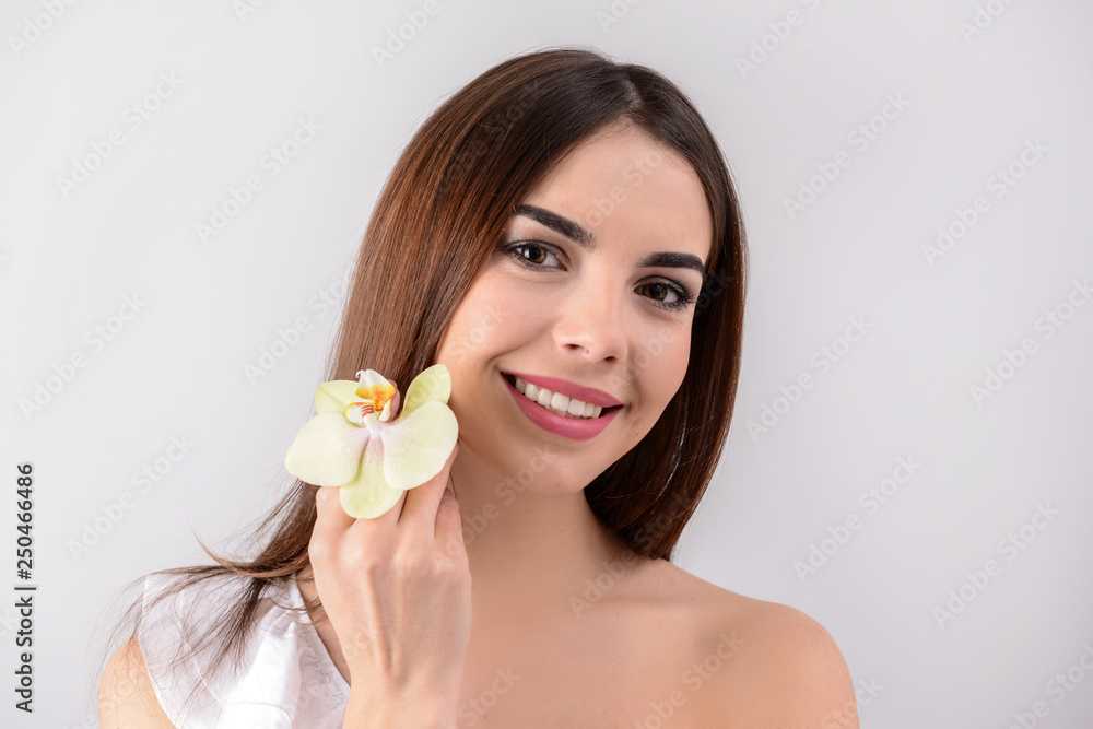 Beautiful young woman with orchid flower on white background Beautiful young woman with orchid flower on white background