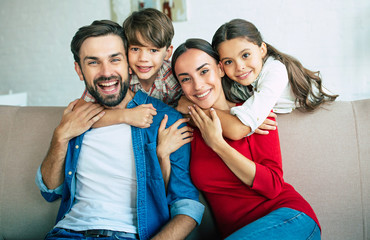 Young happy family relax together at home smiling and hugging