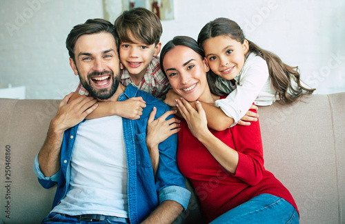 Young happy family relax together at home smiling and hugging