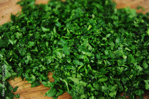 Choped fresh juicy parsley on a wooden cutting board closeup. Natural vitamins, background
