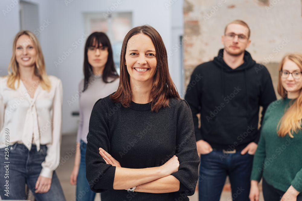 Obraz premium Smiling woman team leader with arms crossed