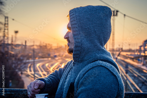 Man in profile with hoodie railway background photo