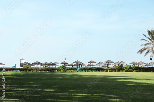 Beautiful landscape with beach umbrellas at tropical resort on sunny day
