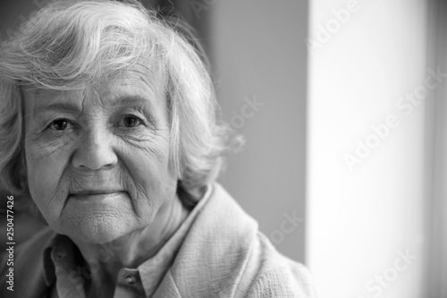 Portrait of elderly woman indoors, space for text. Black and white effect