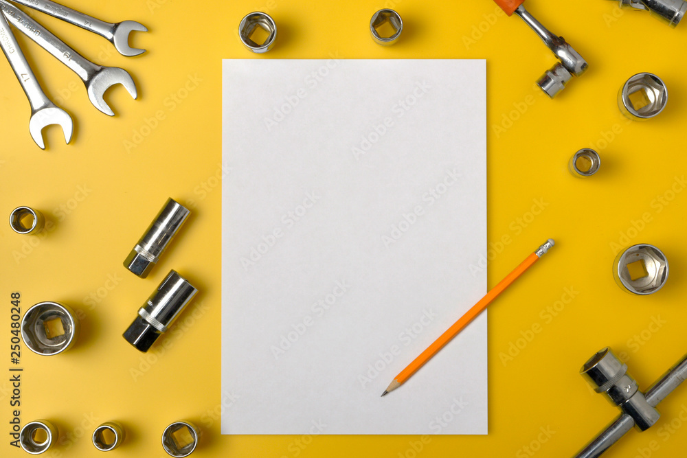 Top view of different wrenches and one monkey wrench on the yellow background. Flat lay. Copy space for text Top view of different wrenches and one monkey wrench on the yellow background. Flat lay. Copy space for text