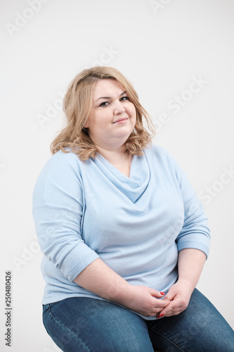 Fotografía Young obese woman in casual blue clothes on a white background in the studio