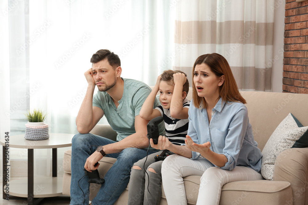 Obraz premium Family playing video games on sofa in living room
