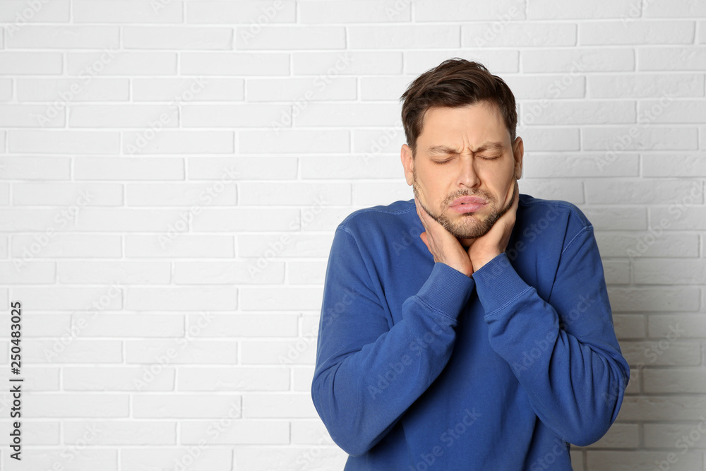 Man suffering from cough near brick wall. Space for text Man suffering from cough near brick wall. Space for text