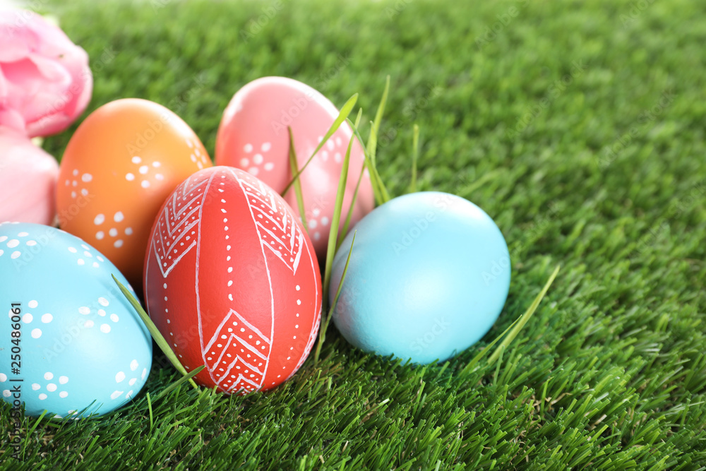 Colorful painted Easter eggs on green grass, closeup
