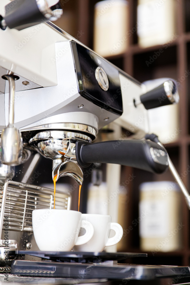 Coffee brewing in coffee machine. Espresso pouring in two cups. Coffee brewing in coffee machine. Espresso pouring in two cups.