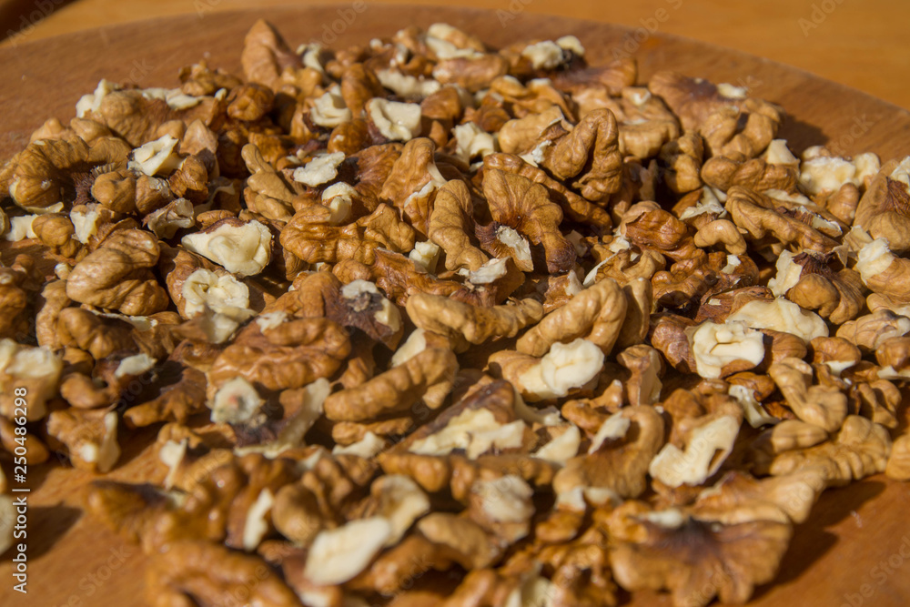Closeup of Peeled Walnuts pile. Walnuts Background on wooden cutting board. Selective Focus, nuts with many different textures Closeup of Peeled Walnuts pile. Walnuts Background on wooden cutting board. Selective Focus, nuts with many different textures