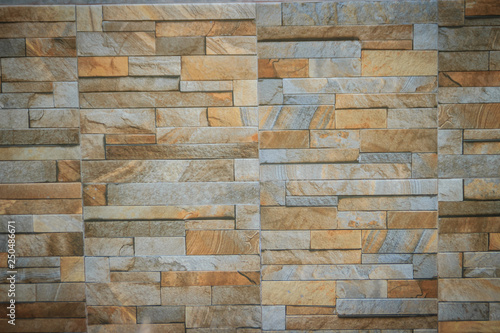 Wall tiles patterned like natural split stone background. Simulated yellow natural stone facade  wall tiles texture.