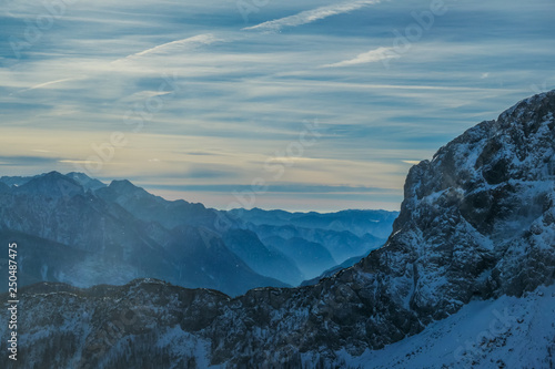 Cloudy and misty morning in Alps, Nassfeld, Austria. Delicate snow fall. Mountain slopes covered with snow. Sharp edges of the Alps. Softly colored sky. a new day begins.