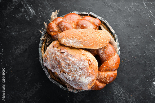 Fényképezés Assortment of bread and baking on a black stone background