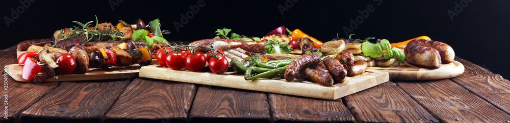 Assorted delicious grilled meat with vegetable on rustic table Assorted delicious grilled meat with vegetable on rustic table