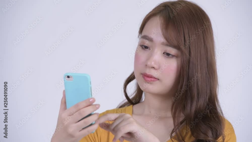 Face of happy young beautiful Asian woman using phone Face of happy young beautiful Asian woman using phone