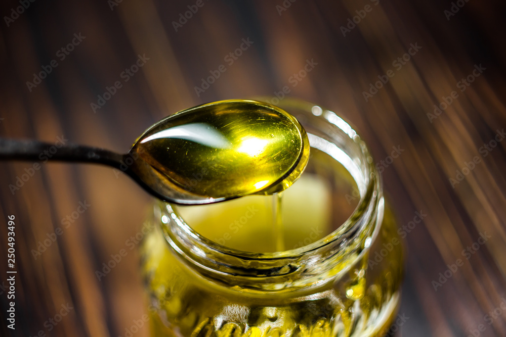 Honey spoon over glass jar