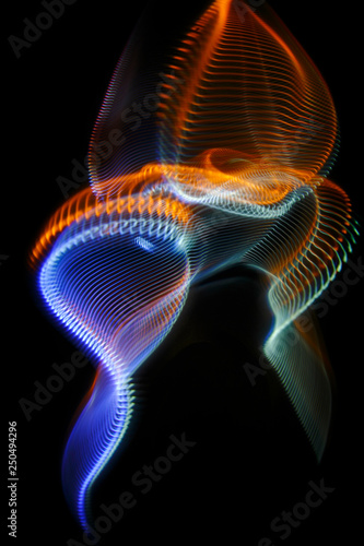 Multicolored twisted ordered parallel lines on a black background. Light in motion. Color abstraction.