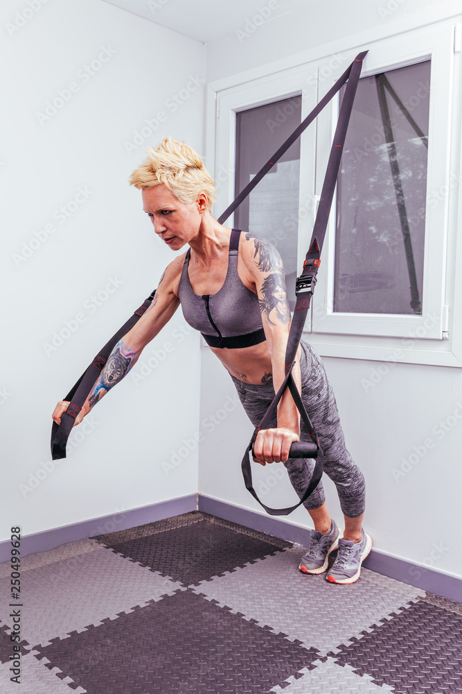 Blonde and athletic woman training in the gym