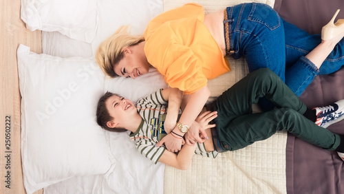 Mother with son on bed, mother and son having fun photo