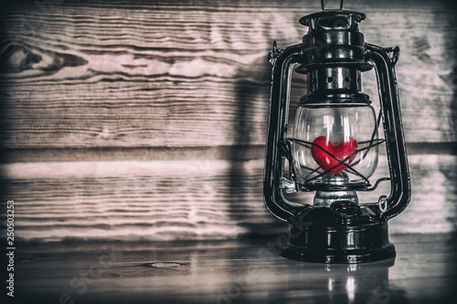 Heart in oil lamp on wooden table. love concept. photo