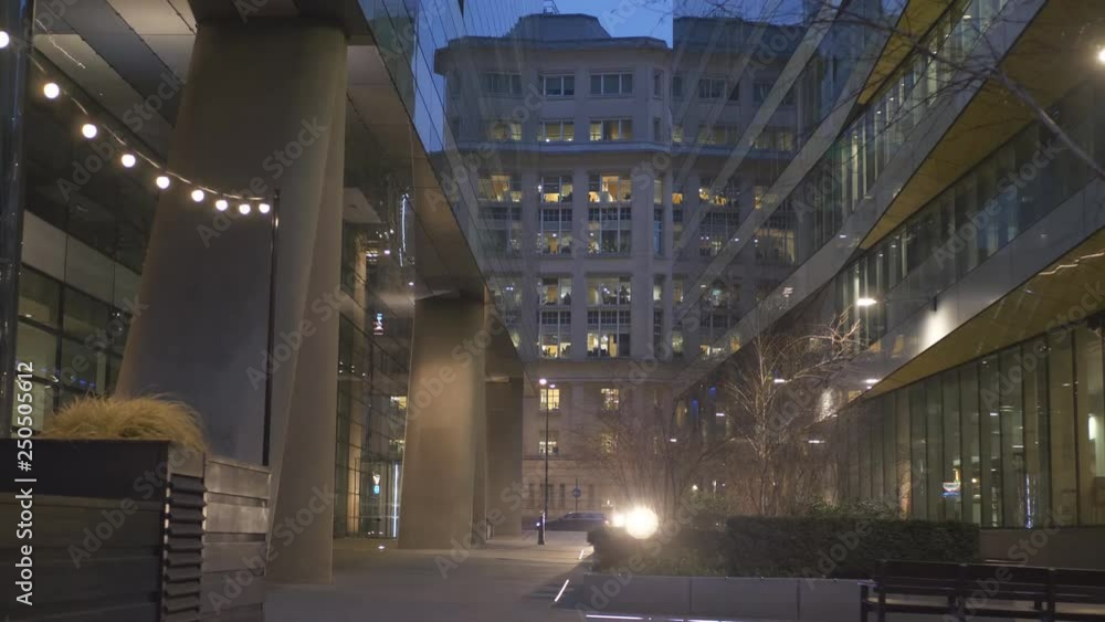 A view of a pathway between office buildings at night. A view of a pathway between office buildings at night.