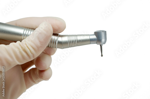 dental handpiece in the hands of the dentist isolated on white background close-up, dental drill, burr photo