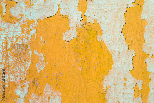 Contrast photograph of an old yellow wall with defects and remnants of fragments of light abstract plaster