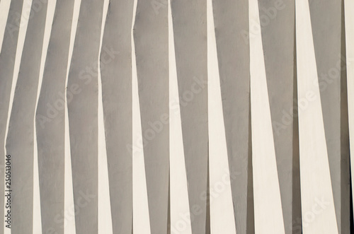 Wave facade of the building. White graphical linear facade of the building. The play of light and shadow. Neutral fashionable background. Light stripes.